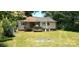 Backyard features a large grassy area, mature trees, and a small porch at 202 N Dilling St, Kings Mountain, NC 28086