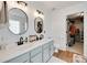 Bright bathroom featuring dual sinks, stylish lighting, and a walk-in closet for convenience and comfort at 2103 Cantata Ct, Matthews, NC 28105