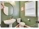 Stylish half bathroom with modern fixtures, a pedestal sink, and elegant green walls at 2103 Cantata Ct, Matthews, NC 28105