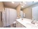 Bright bathroom featuring a double vanity, shower with curtain, and a toilet in neutral tones at 2635 Mahogany Ln, Hickory, NC 28602