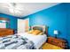 Stylish bedroom with vibrant blue walls, wood furniture, ceiling fan, and a comfortable quilt on the bed at 2635 Mahogany Ln, Hickory, NC 28602