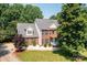 Two-story brick home featuring a manicured lawn, dark shutters, and a gable roof, framed by mature trees and verdant landscaping at 2635 Mahogany Ln, Hickory, NC 28602