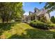 Daytime view of a charming home featuring a covered porch, well-maintained lawn, and lush landscaping at 315 Talon Dr, Salisbury, NC 28147