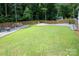 Open backyard featuring a lush lawn, firepit area and wooded border, all enclosed with a wooden fence at 317 Sugar Creek Xing, Fort Mill, SC 29715