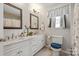 Bright bathroom with double vanity, framed mirrors, and wood look flooring at 317 Sugar Creek Xing, Fort Mill, SC 29715