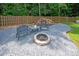 Backyard firepit area with chairs and stacked firewood, great for outdoor gatherings in a private setting at 317 Sugar Creek Xing, Fort Mill, SC 29715