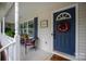 Inviting front porch features a blue front door adorned with wreath and charming porch decor at 317 Sugar Creek Xing, Fort Mill, SC 29715