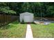 Backyard shed with adjacent seating and stacked firewood, set within a fully fenced yard at 317 Sugar Creek Xing, Fort Mill, SC 29715