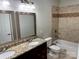 Bathroom with granite countertop, dual sinks, a decorative mirror, and a shower/tub combo with tile surround at 3837 1St Street Nw Ln, Hickory, NC 28601