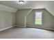 A bedroom with neutral walls, carpet flooring, and a window with a view of a brick home at 3837 1St Street Nw Ln, Hickory, NC 28601