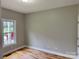 A bedroom with hardwood floors, neutral walls, white trim, and a window overlooking the neighborhood at 3837 1St Street Nw Ln, Hickory, NC 28601