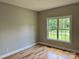 A bedroom with hardwood floors, light neutral paint, and a window providing ample light and a view at 3837 1St Street Nw Ln, Hickory, NC 28601
