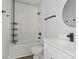 Bathroom featuring modern black fixtures, white marble-look tile, and a built-in bathtub and shower at 405 E Broad St, Salisbury, NC 28144