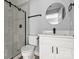 Bathroom featuring a glass shower, modern fixtures, and a round mirror over the vanity at 405 E Broad St, Salisbury, NC 28144