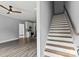 Open-concept living area with hardwood floors, white staircase, and a glimpse into the modern kitchen at 405 E Broad St, Salisbury, NC 28144