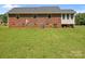 Back view of a brick house with a screened-in porch and ample backyard space at 416 Park Ave, Granite Quarry, NC 28072