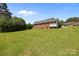 Expansive backyard featuring a well-maintained lawn and a two-story brick home with a screened-in porch, perfect for outdoor living at 416 Park Ave, Granite Quarry, NC 28072