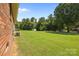Large backyard with mature trees providing shade and privacy and a shed at 416 Park Ave, Granite Quarry, NC 28072