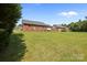 A wide shot of a lush green backyard with mature trees and a partial view of the home's exterior at 416 Park Ave, Granite Quarry, NC 28072