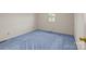 A bedroom with a window, light blue carpeting, and neutral walls for a comfortable aesthetic at 416 Park Ave, Granite Quarry, NC 28072