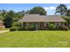 Well-maintained brick home with a green lawn, blue shutters, and mature trees at 416 Park Ave, Granite Quarry, NC 28072
