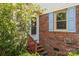 Charming entryway with brick facade, light blue shutters, and blooming shrubbery at 416 Park Ave, Granite Quarry, NC 28072