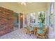 Charming sunroom with brick wall and glass table with four chairs at 416 Park Ave, Granite Quarry, NC 28072