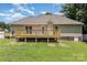 View of the back of the house with a spacious wooden deck and a well-maintained lawn at 608 Red Hawk Way, Clover, SC 29710