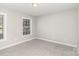 Bright bedroom with neutral walls and carpet, and windows allowing natural light into the room at 608 Red Hawk Way, Clover, SC 29710