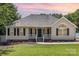 Charming single-story home with a manicured lawn, a welcoming porch, and black shutters at 608 Red Hawk Way, Clover, SC 29710