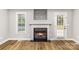 Cozy living room featuring a classic fireplace, hardwood floors, and plenty of natural light at 608 Red Hawk Way, Clover, SC 29710