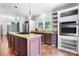 Spacious kitchen featuring a central island cooktop, granite countertops, and stainless steel appliances at 7648 Forest Oak Dr, Denver, NC 28037