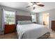 Cozy bedroom features a comfortable bed, neutral walls, two windows, and an ensuite bathroom at 864 Pointe Andrews Dr, Concord, NC 28025