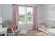 This Bedroom features soft pink accents, a comfortable rocking chair, and a crib with stuffed animals at 864 Pointe Andrews Dr, Concord, NC 28025