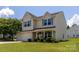 Charming two-story home featuring a well-manicured lawn, attached garage, and inviting front porch at 864 Pointe Andrews Dr, Concord, NC 28025