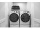 Convenient laundry room equipped with modern washer and dryer units and built in shelving above at 9921 Oaklawn Nw Blvd, Huntersville, NC 28078
