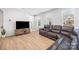 Bright living room featuring a large, comfortable leather sectional sofa and wood flooring at 9921 Oaklawn Nw Blvd, Huntersville, NC 28078