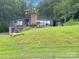 Charming two-story home with a brick chimney, deck, garage, and a lush green lawn on a sloped lot at 109 Joe Teague Rd, Hickory, NC 28601