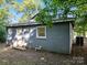 Back exterior featuring flat roof, siding, and access to the yard at 116 Honeywood Ave, Charlotte, NC 28216