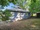 Rear of the property showcasing the foundation, siding, and small backyard at 116 Honeywood Ave, Charlotte, NC 28216