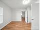 Bright bedroom with hardwood floors, white walls, ensuite bathroom, and natural light streaming through a large window at 116 Honeywood Ave, Charlotte, NC 28216