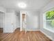 Bright bedroom with hardwood floors, white walls, ensuite bathroom, and natural light streaming through a large window at 116 Honeywood Ave, Charlotte, NC 28216