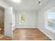 Bright bedroom with hardwood floors, white walls, and natural light streaming through large windows, highlighting the airy space at 116 Honeywood Ave, Charlotte, NC 28216