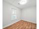 Bright bedroom with wood floors, a window with blinds, and fresh, neutral paint at 116 Honeywood Ave, Charlotte, NC 28216