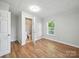 Bright bedroom with hardwood floors, white walls, ensuite bathroom, and natural light streaming through a large window at 116 Honeywood Ave, Charlotte, NC 28216