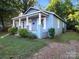 Charming light blue single-story home with a covered porch, white columns, trimmed windows, and lovely curb appeal at 116 Honeywood Ave, Charlotte, NC 28216