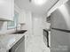 Updated kitchen with marble floors, stainless appliances, white cabinets and countertops at 116 Honeywood Ave, Charlotte, NC 28216