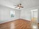 Open living room featuring hardwood floors, natural light, and a ceiling fan at 116 Honeywood Ave, Charlotte, NC 28216