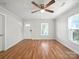 Bright living room with hardwood floors, ceiling fan, and natural light from multiple windows at 116 Honeywood Ave, Charlotte, NC 28216