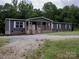 Charming single-story home with a covered front porch and a spacious gravel driveway nestled on a wooded lot at 1856 Kemp Cir, Shelby, NC 28152